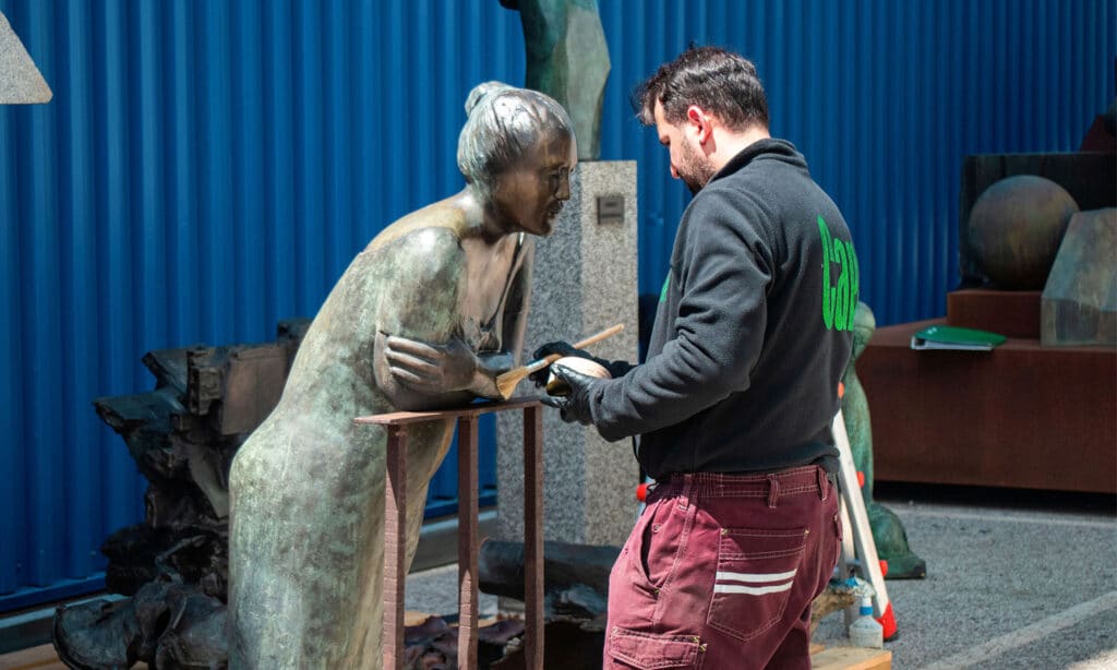 Wax application and maintenance of bronze sculptures in a specialized workshop