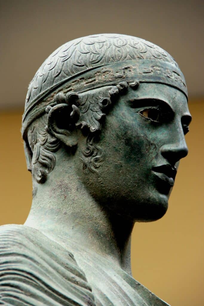 A close-up of the Charioteer of Delphi, an ancient Greek bronze sculpture that highlights the significance of bronze in the history of sculpture.