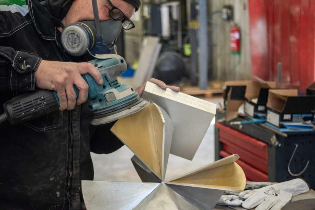 Operator adjusting the details of the Kineo trophy with care and precision craftsmanship.