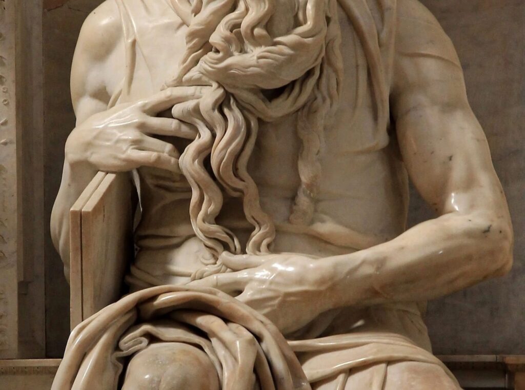 Hands of Michelangelo's Moses with the beard and the Tablets of the Law