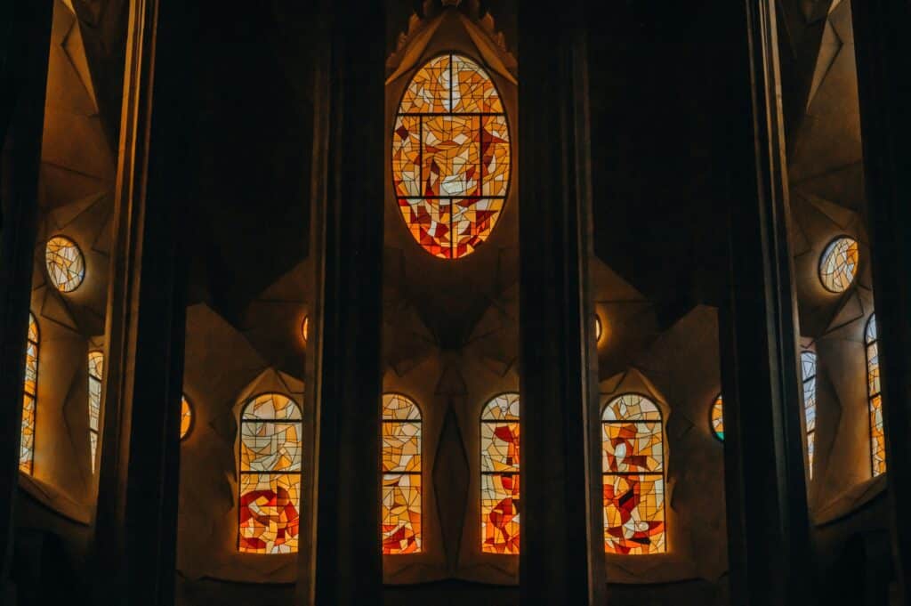The stained-glass windows of the Sagrada Família in Barcelona, with their warm light, Antoni Gaudí’s architecture, and the symbolism within the modernist church