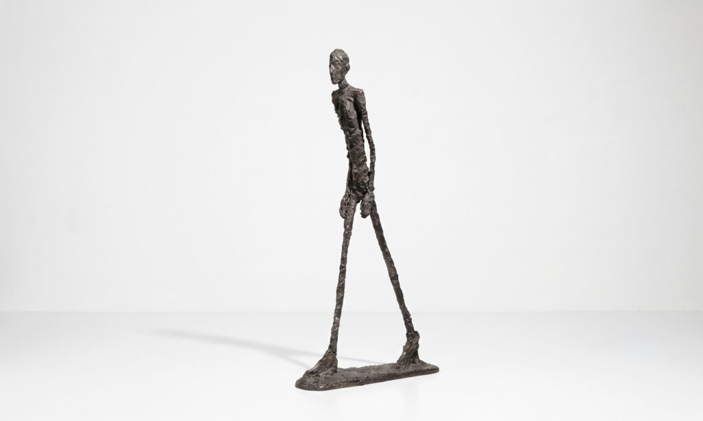 L’Homme qui marche I de Giacometti, figura alargada de bronce caminando