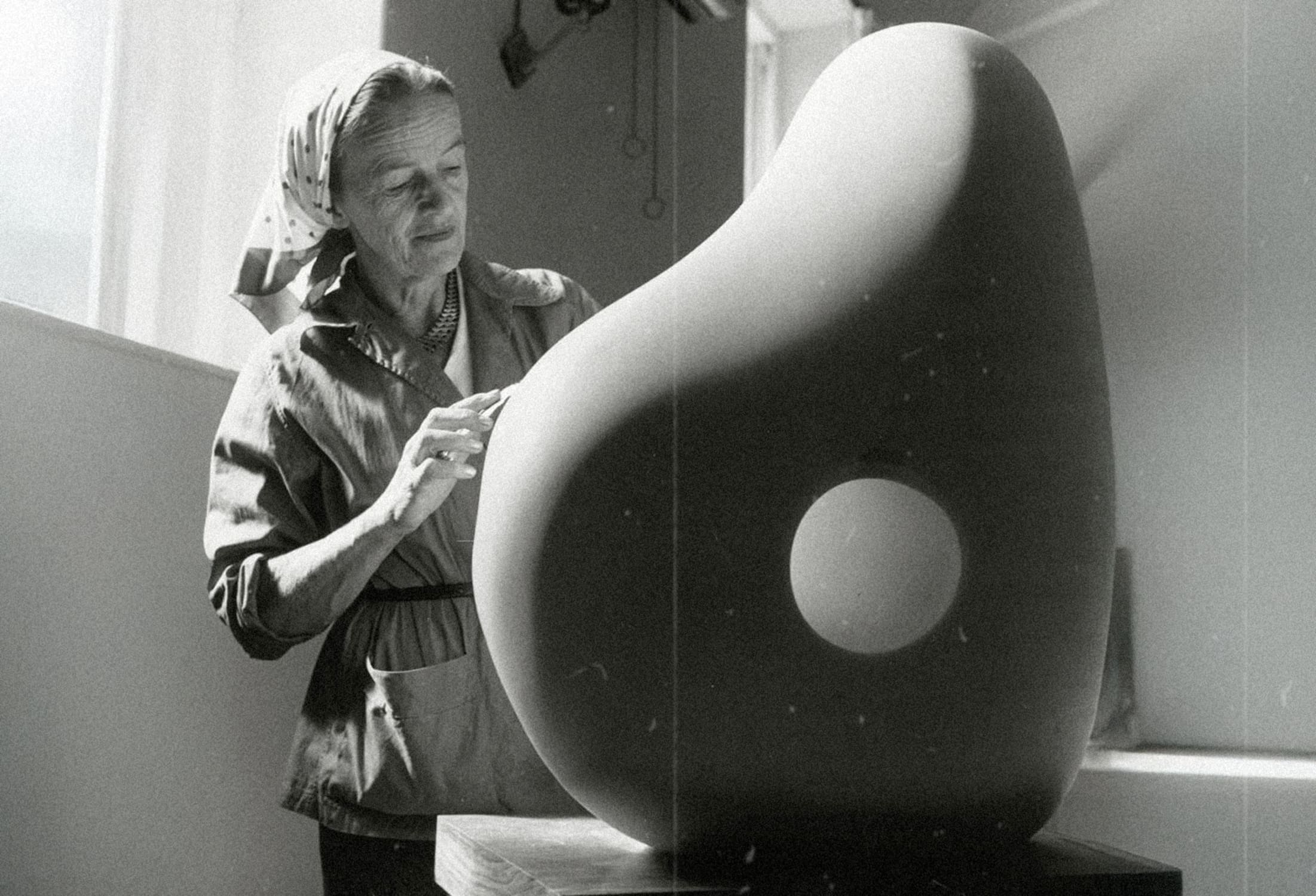 Fotografía antigua de Barbara Hepworth esculpiendo en su taller.