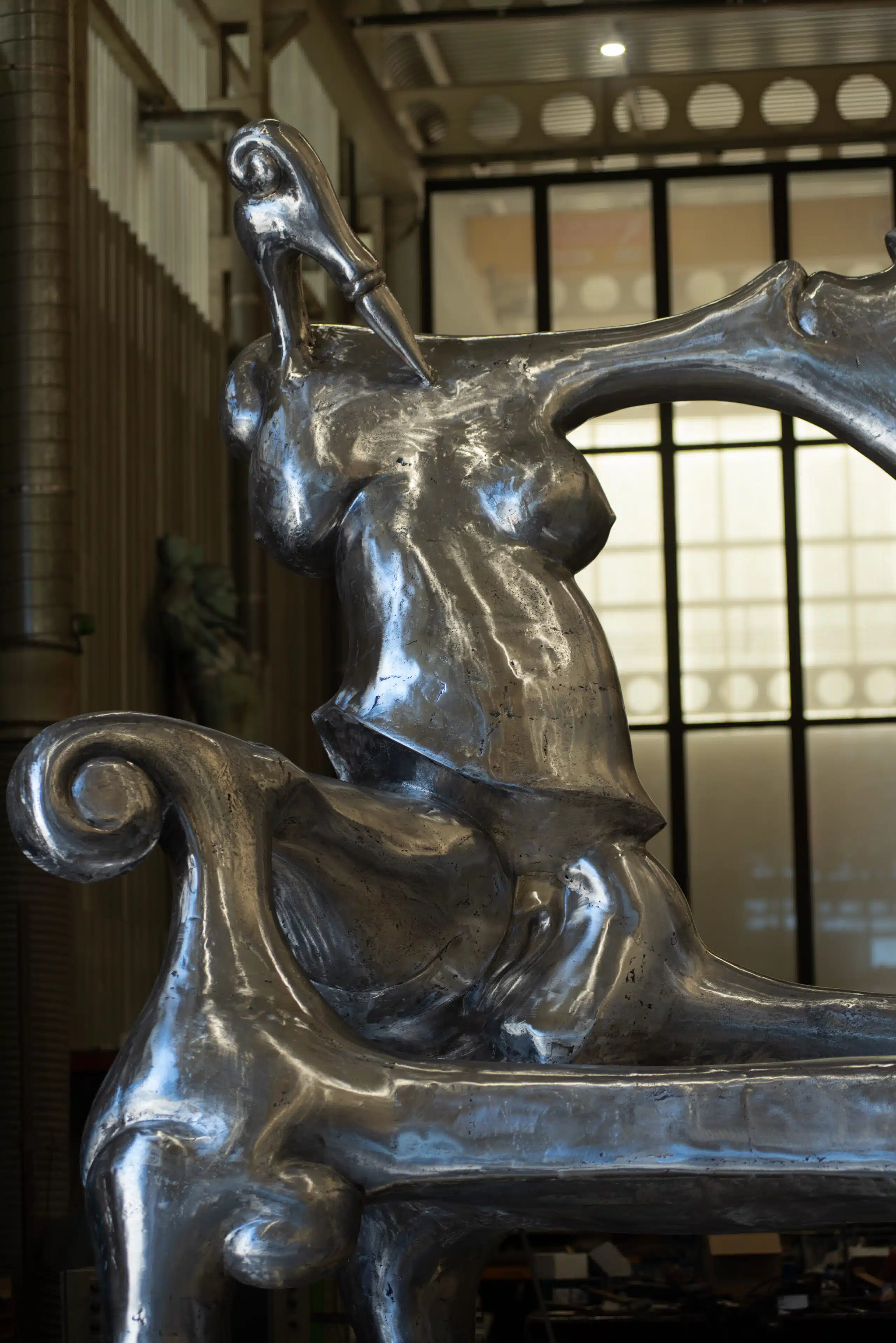 Left side view of the sculpture TOVAR The Chair, showing the female silhouette intertwined with other human figures, characteristic of Ivan Tovar's surrealism.