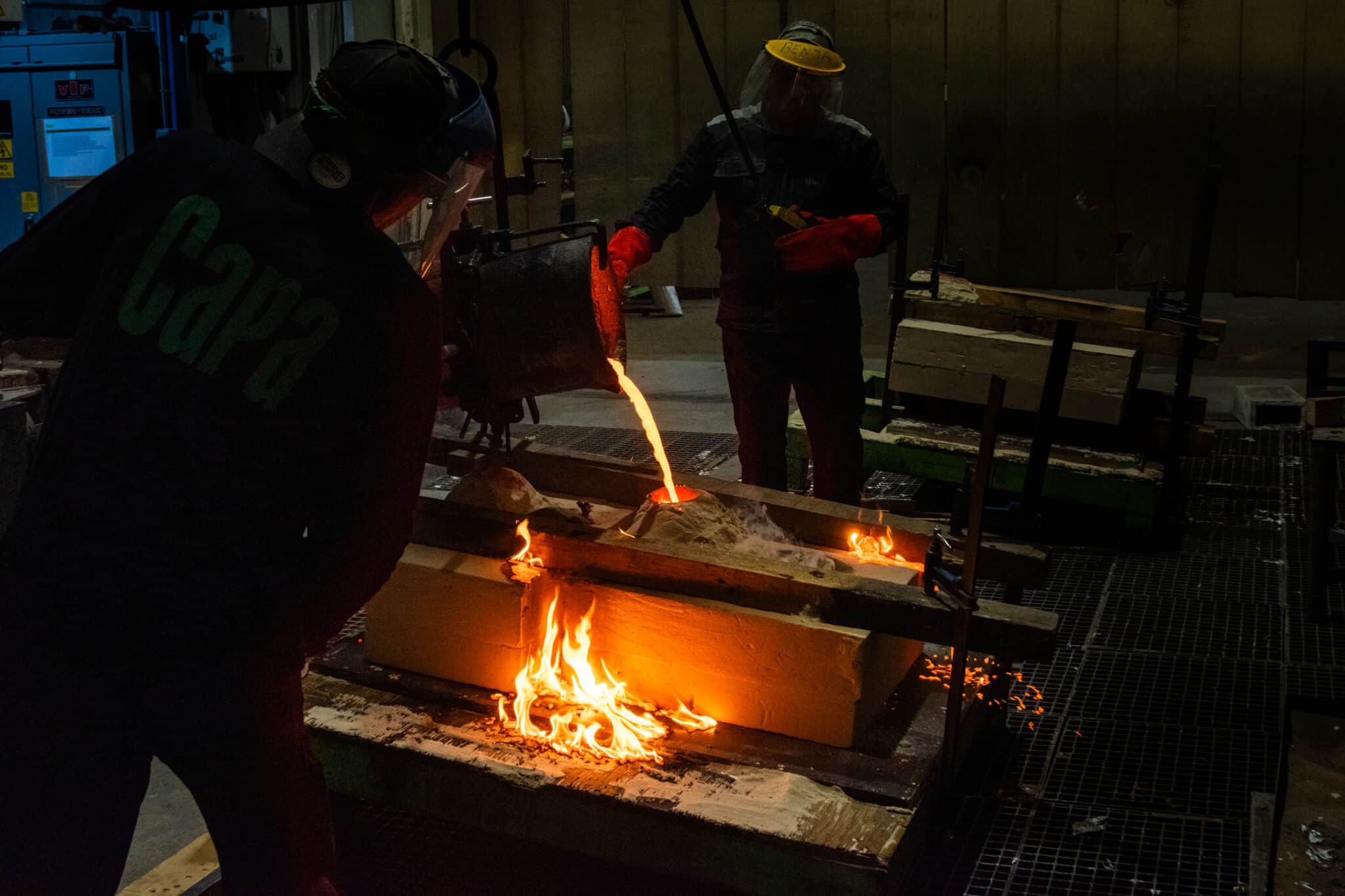 Proceso de fundición de esculturas de bronce en Capa Esculturas, con colada de metal fundido dentro de un taller de fundición artística.