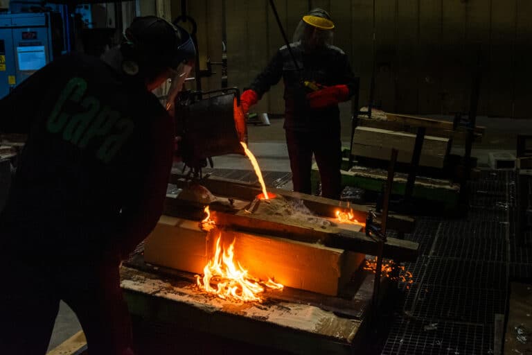 Proceso de fundición de esculturas de bronce en Capa Esculturas, con colada de metal fundido dentro de un taller de fundición artística.