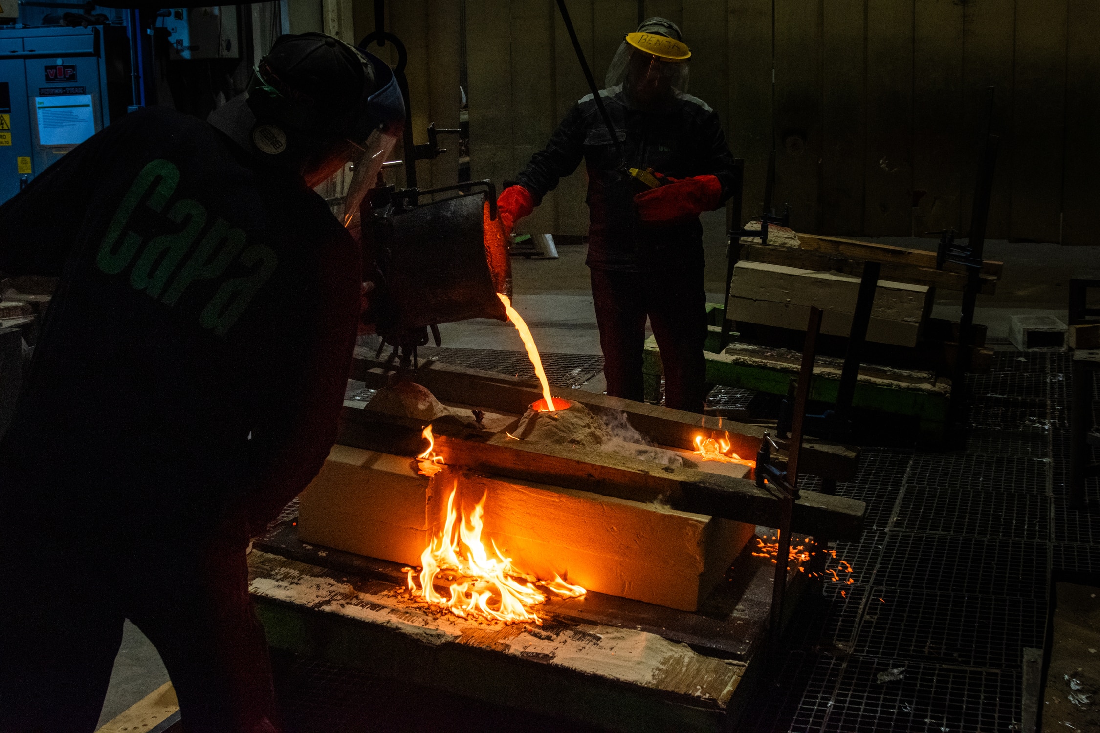 Proceso de fundición de esculturas de bronce en Capa Esculturas, con colada de metal fundido dentro de un taller de fundición artística.