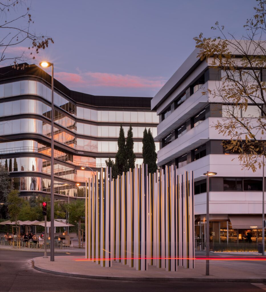 Sculpture “Recuerdo Vivo” (Living Memory) illuminated by the evening light, surrounded by modern buildings in Chamartín, Madrid.