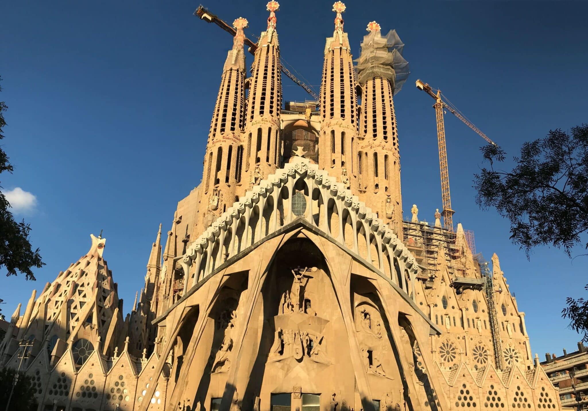 Sagrada Familia Barcelona fachada principal con torres y grúas, obra de Antoni Gaudí en construcción con arquitectura modernista y escultura monumental
