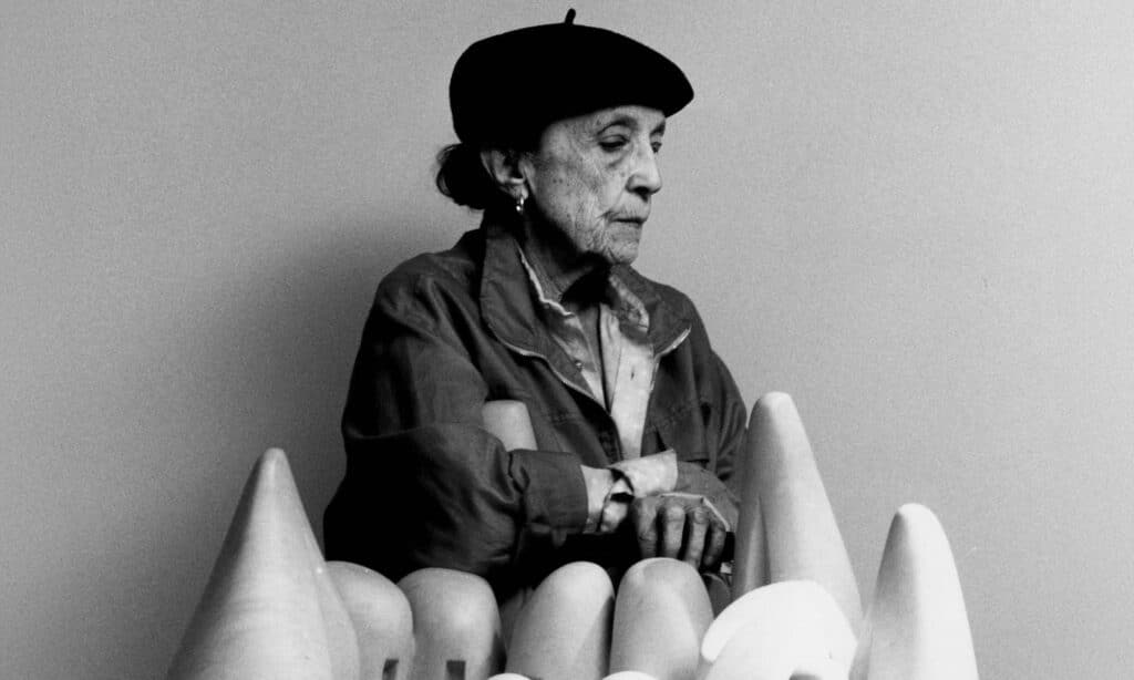 Louise Bourgeois junto a una de sus obras escultóricas, artista creadora de la escultura de la araña del Guggenheim Bilbao