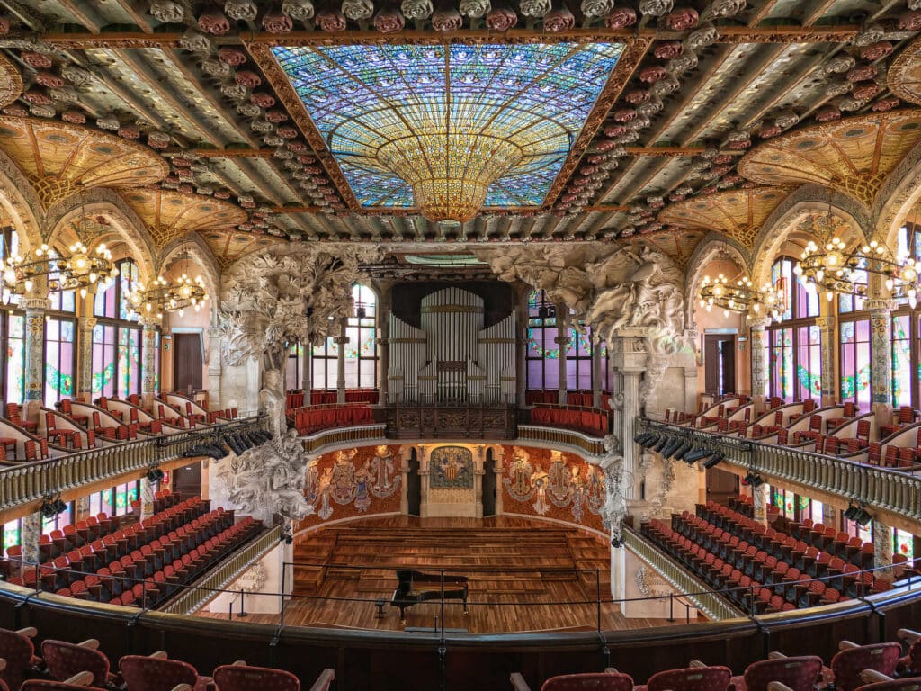 Interior del Palau de la Música Catalana en Barcelona, con ornamentación modernista, esculturas, vidrieras y elementos decorativos.