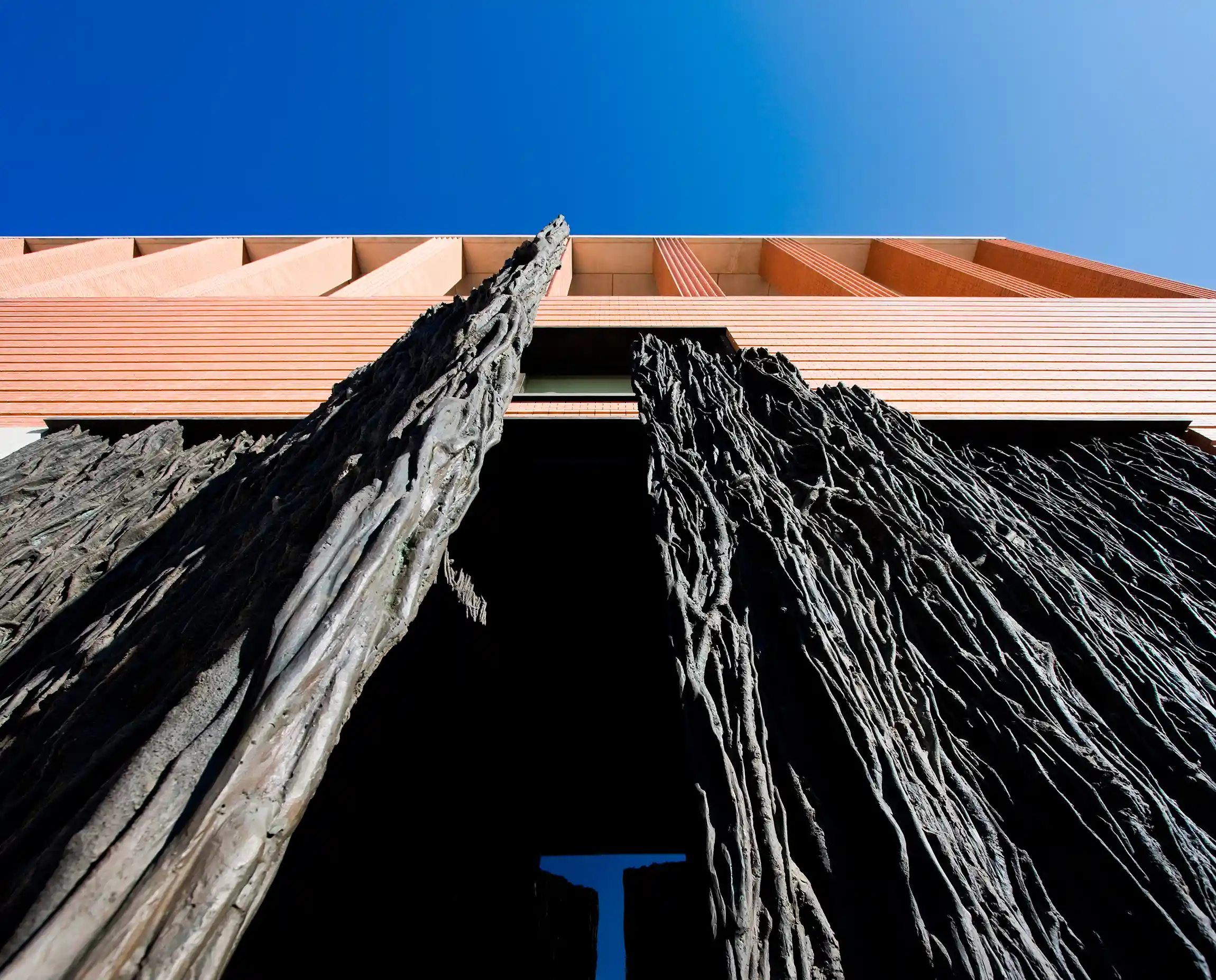 Perspectiva ascendente del Portón-Pasaje al Museo del Prado. Obra de Cristina Iglesias bajo el cielo azul, una obra maestra moderna