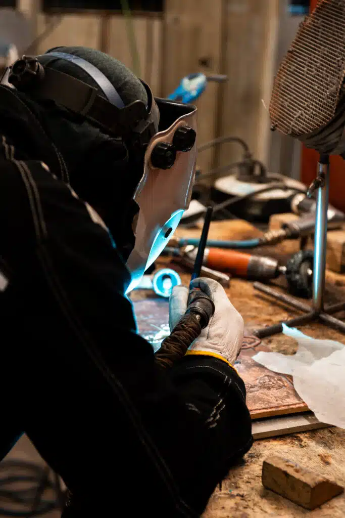 A Capa Esculturas worker carving a commemorative bronze plaque for a centenary store in Madrid.