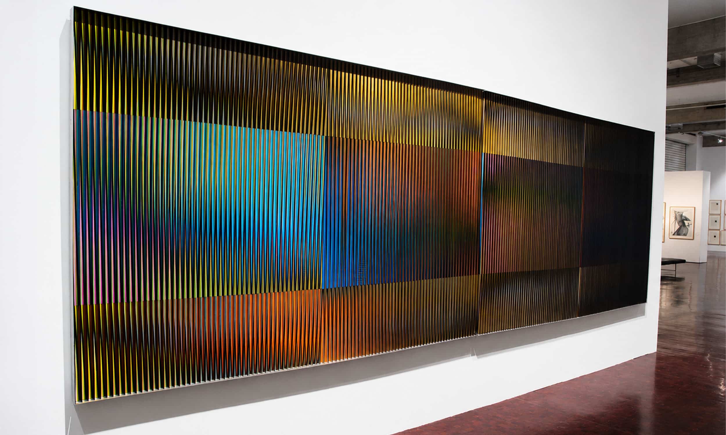 Physichromie de Carlos Cruz-Diez expuesta en sala, con relieve, color y movimiento óptico que cambia según el punto de vista del espectador.