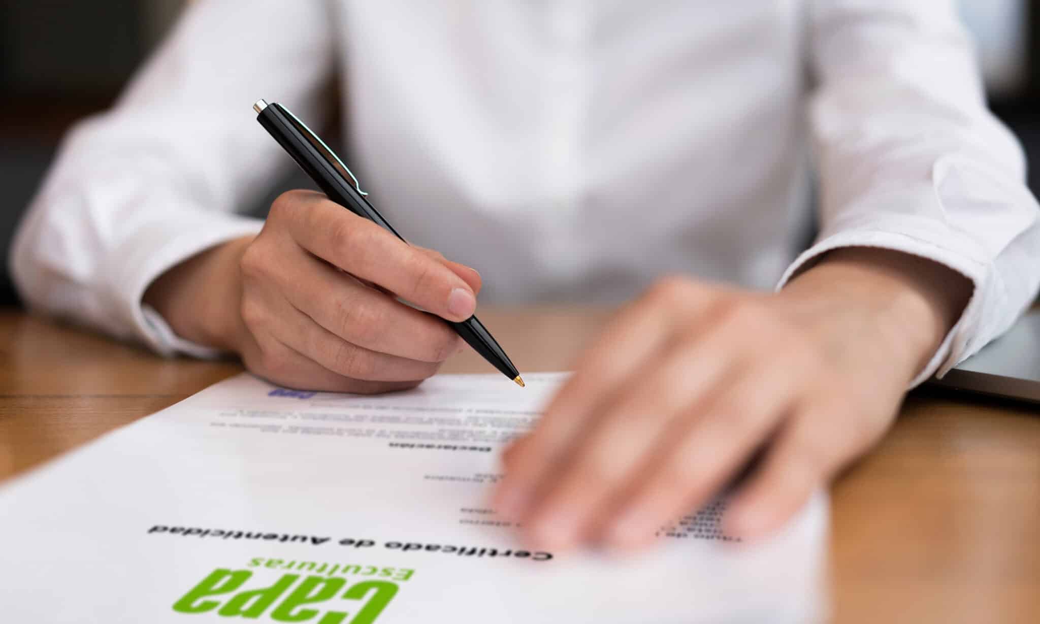 Mano firmando certificado de autenticidad de Capa Esculturas para obras de arte certificadas.